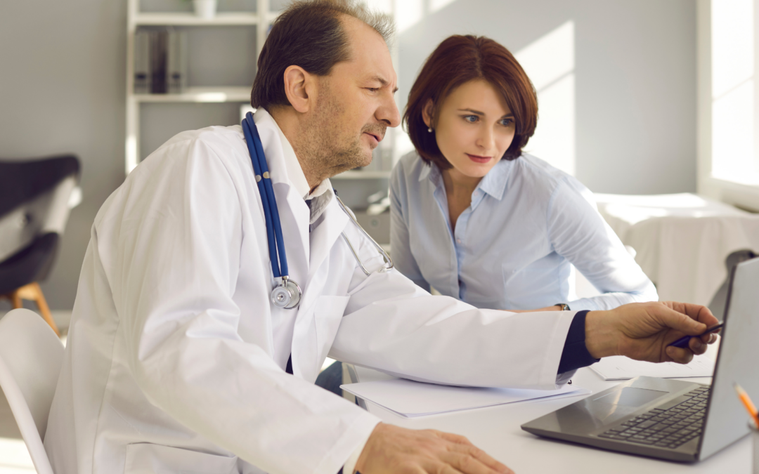 Woman and a doctor looking at a computer going over test results
