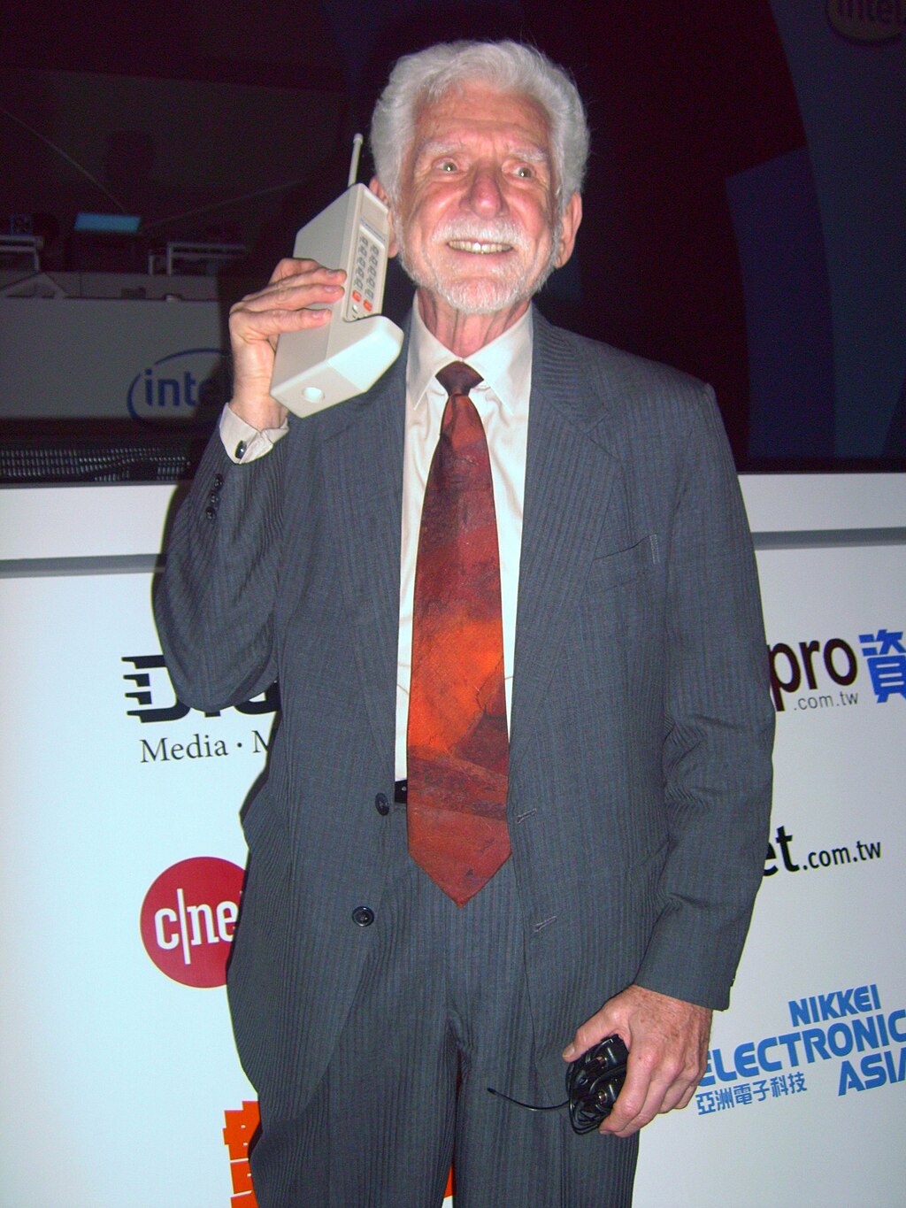 Martin cooper holding the original motorola phone