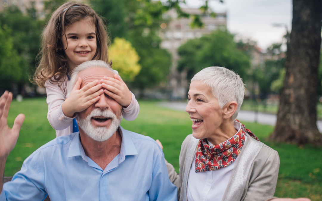 Happy older couple smiling with a young girl