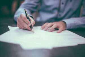 Man signing paperwork on a desk