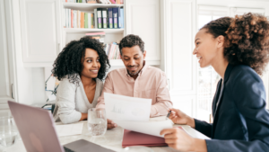 Couple looking at loan paperwork smiling at each other 